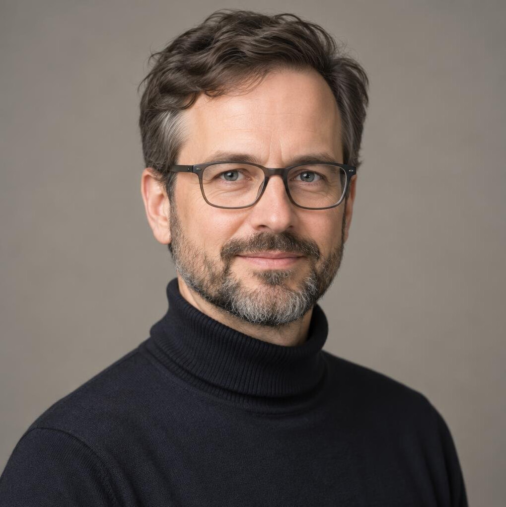 Studio portrait of a German man with a beard and glasses